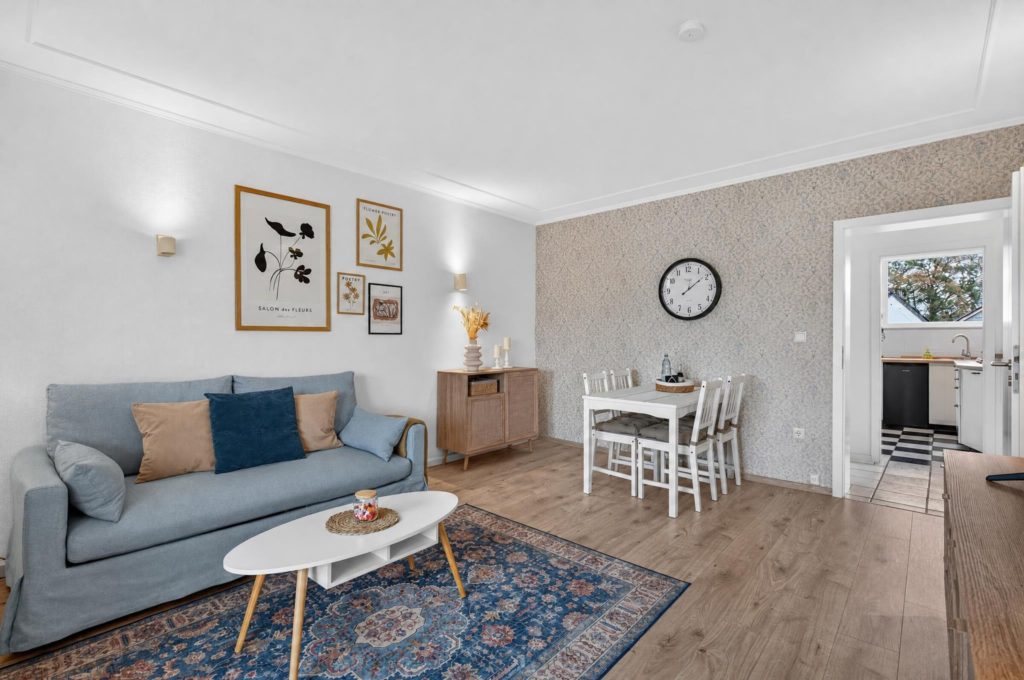 Helles Wohnzimmer mit blauem Sofa und Essbereich in einer Wohnung in Kaarst