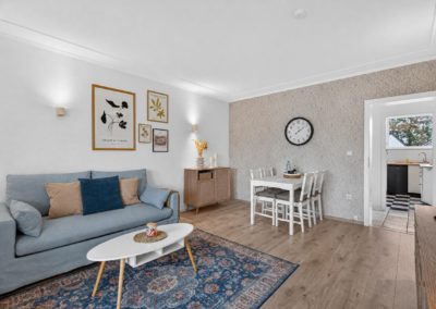 Helles Wohnzimmer mit blauem Sofa und Essbereich in einer Wohnung in Kaarst