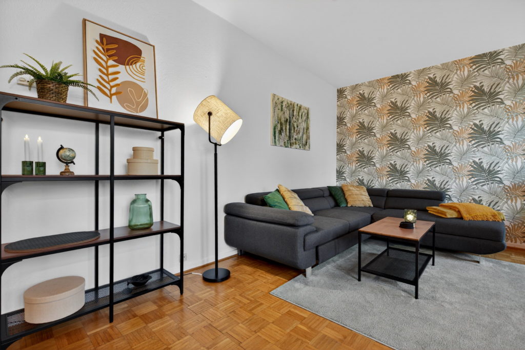 Wohnzimmer mit grauem Sofa und Regal in einer möblierten Wohnung in Krefeld