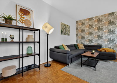 Wohnzimmer mit grauem Sofa und Regal in einer möblierten Wohnung in Krefeld